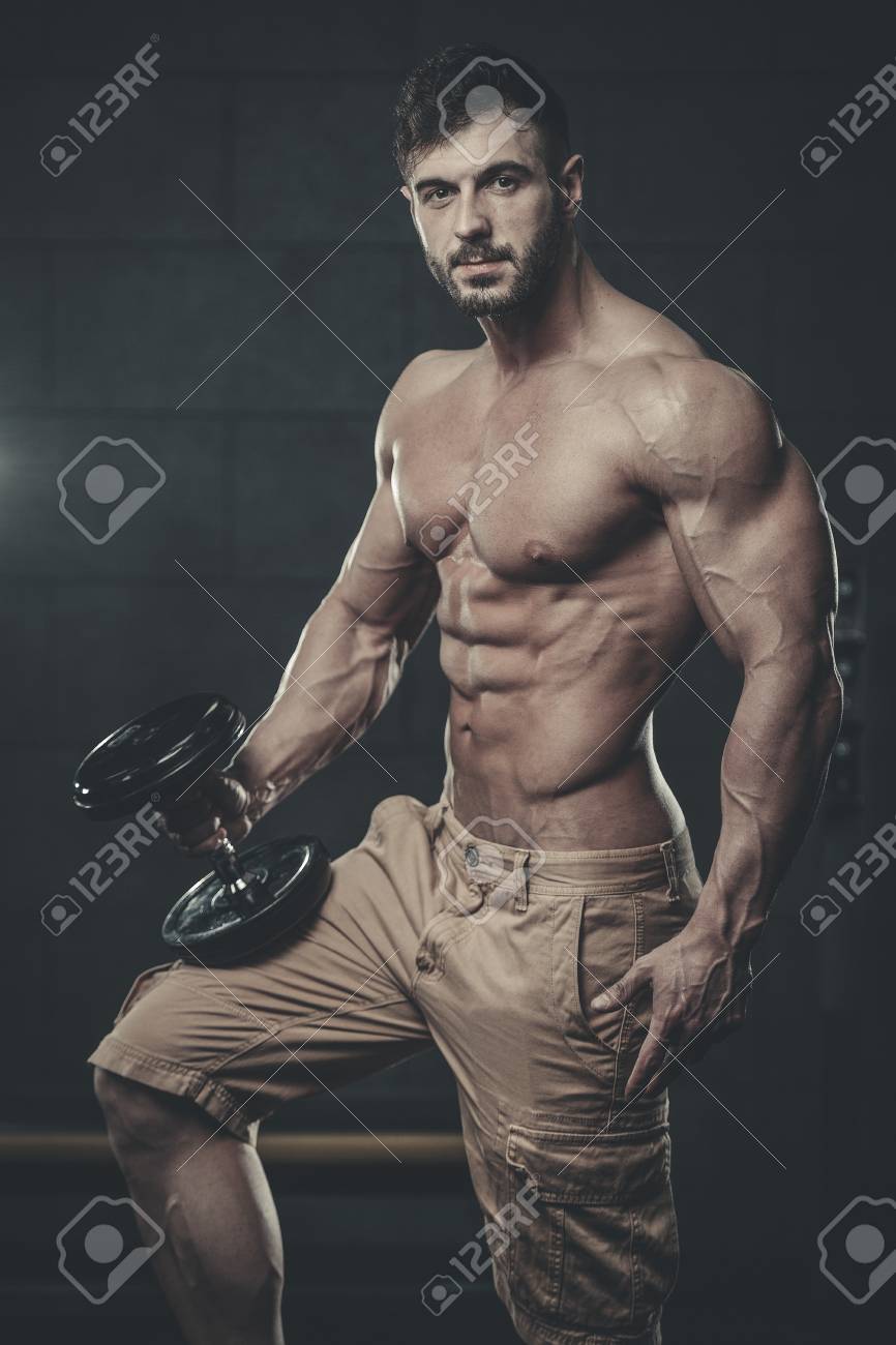 魅力的な若い筋肉セクシーな白人男性のモデル出演の男性は 筋肉をポンプでくみ上げ フィットネスとボディービルの概念をポーズを取るジムでトレーニングを行います の写真素材 画像素材 Image