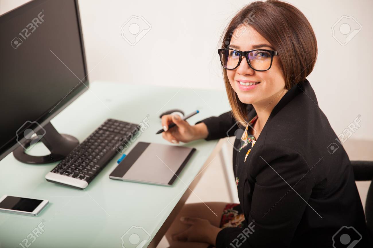 かなり若いフリーランスのデザイナーの眼鏡をかけて事務所でグラフィック タブレットに取り組んで の写真素材 画像素材 Image