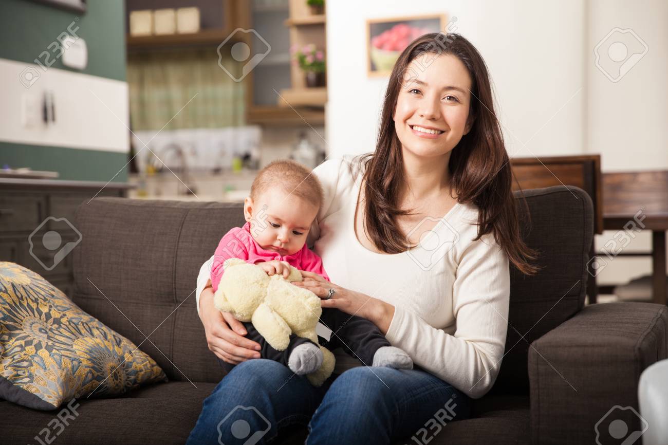 家に女の赤ちゃんの世話かわいいベビーシッターの肖像画 の写真素材 画像素材 Image