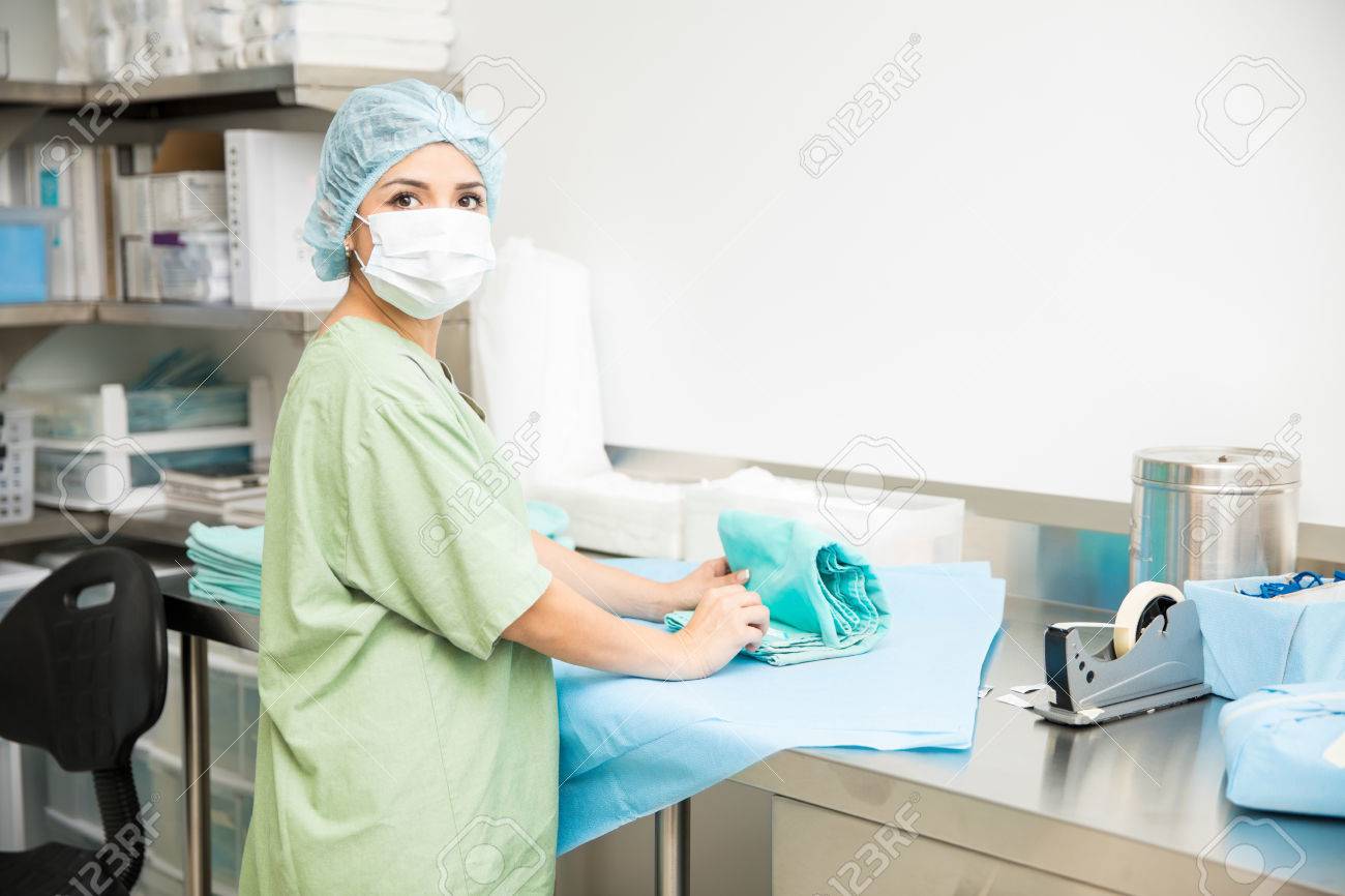Beautiful woman packing clean and sterile clothing and scrubs in a hospital - 67176582 Beautiful woman packing clean and sterile clothing and scrubs in a hospital - 67176582