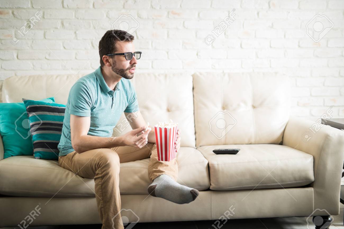 リビングルームで3d 映画を楽しむ自宅で楽しいとリラックスした午後を持つ魅力的な男 の写真素材 画像素材 Image リビングルームで3d 映画を楽しむ自宅で楽しいとリラックスした午後を持つ魅力的な男 の写真素材 画像素材 Image