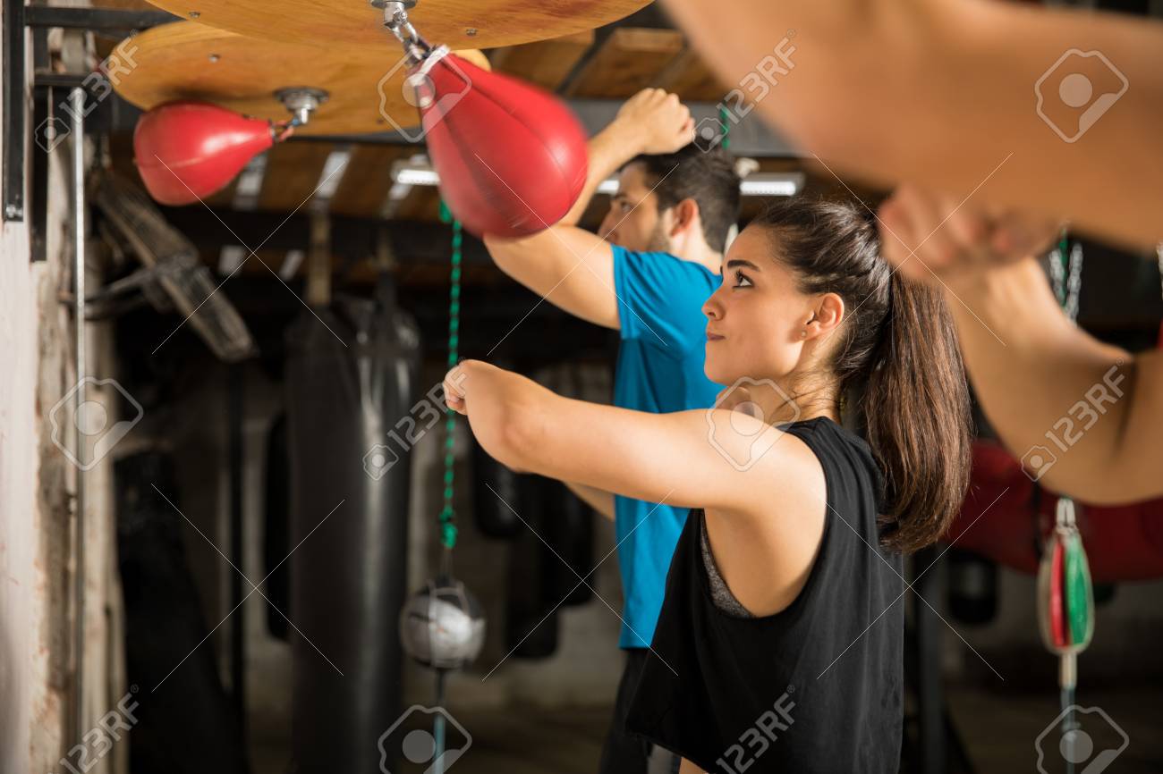Pretty Young Woman Training With A Speed Bag With A Group Of People In A  Boxing Gym Stock Photo, Picture and Royalty Free Image. Image 86875450.