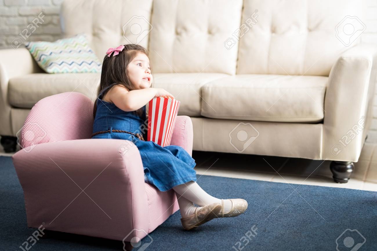 Cute Little Baby Girl Sitting On Couch 