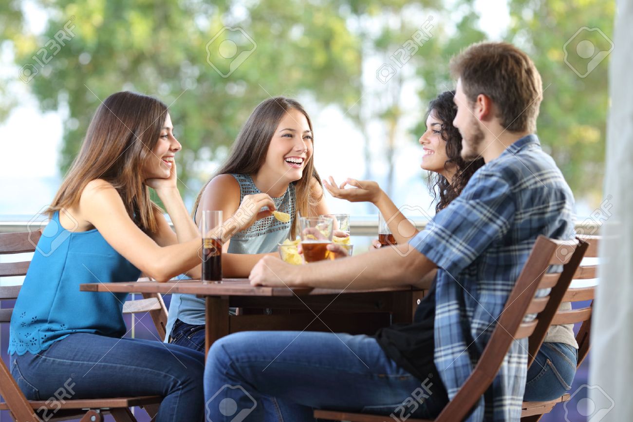 Group of four friends talking and drinking sitting in a terrace at home - 51824821 Group of four friends talking and drinking sitting in a terrace at home - 51824821