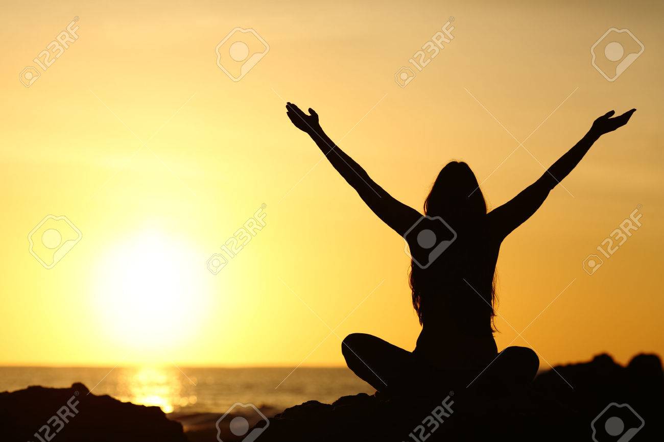 Back view portrait silhouette of a happy woman raising arms in a new day looking at warm sun at sunrise on the beach with the sea in a beautiful background - 60223164 Back view portrait silhouette of a happy woman raising arms in a new day looking at warm sun at sunrise on the beach with the sea in a beautiful background - 60223164