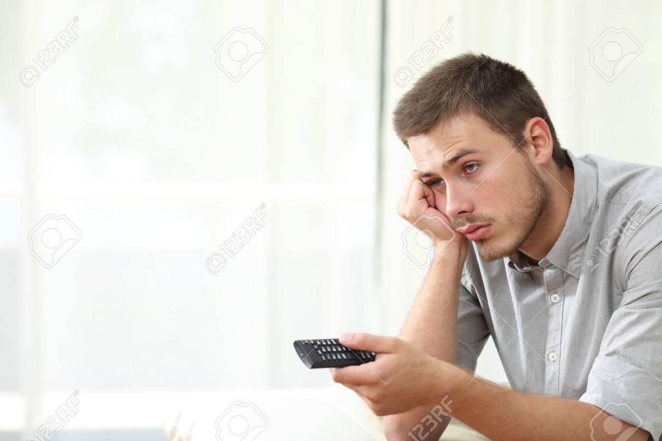 Bored Man Watching Tv And Zapping Sitting On A Couch At Home Stock ... Bored Man Watching Tv And Zapping Sitting On A Couch At Home Stock ...