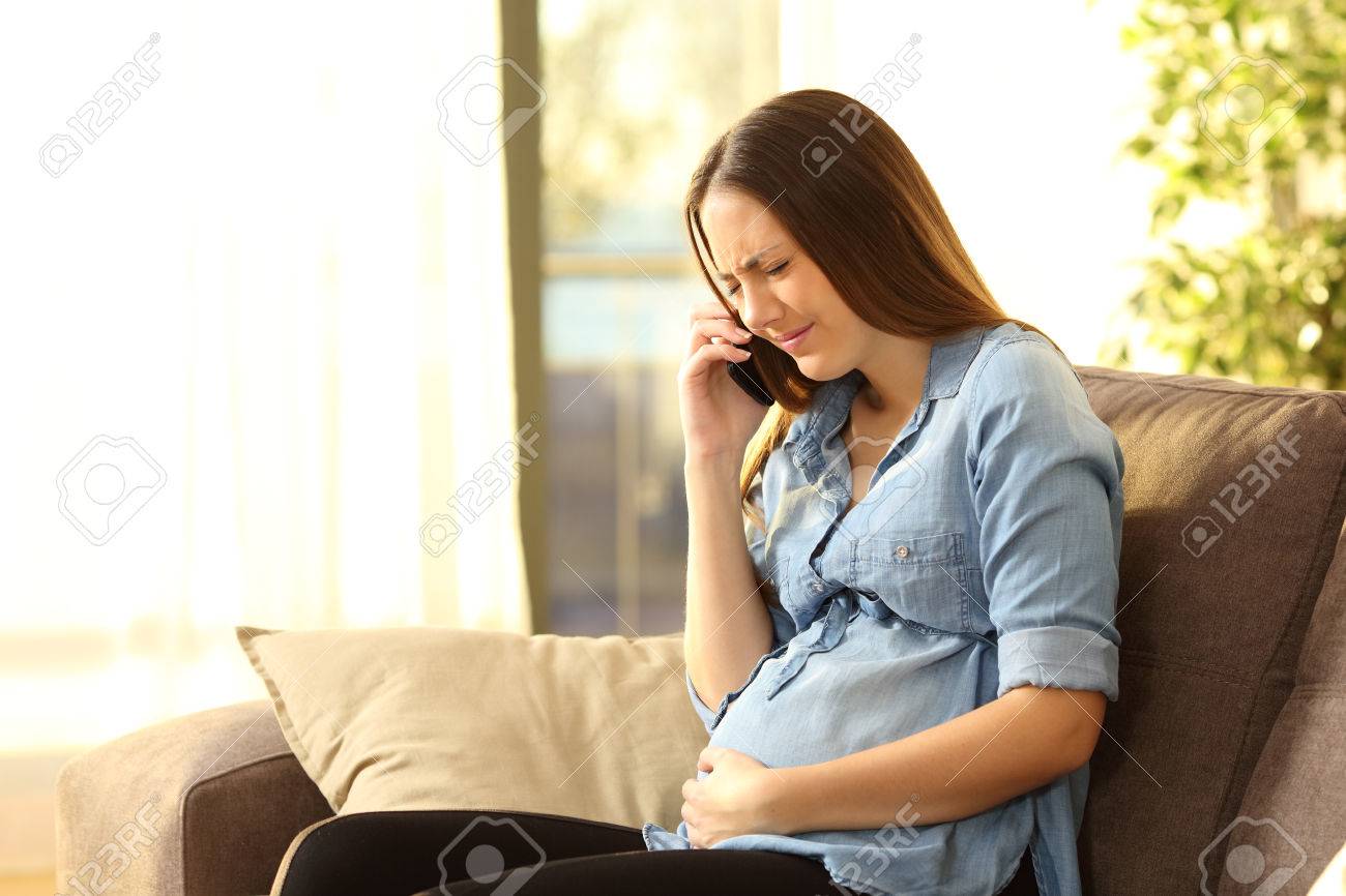 painful pregnant young woman calling medical assistance on phone free medical assistance