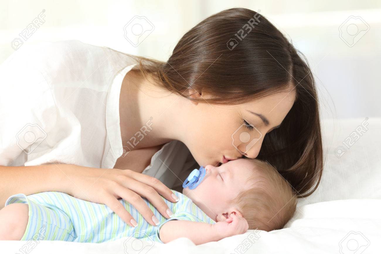 Vue De Cote Portrait D Une Mere Affectueuse Embrassant Son Bebe En Train De Dormir Sur Un Lit Banque D Images Et Photos Libres De Droits Image Vue De Cote Portrait D Une Mere Affectueuse Embrassant Son Bebe En Train De Dormir Sur Un Lit Banque D Images Et Photos Libres De Droits Image