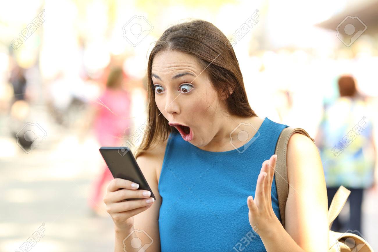 通りにスマート フォンの衝撃的なニュースを受けて女性をびっくり の写真素材 画像素材 Image 9973