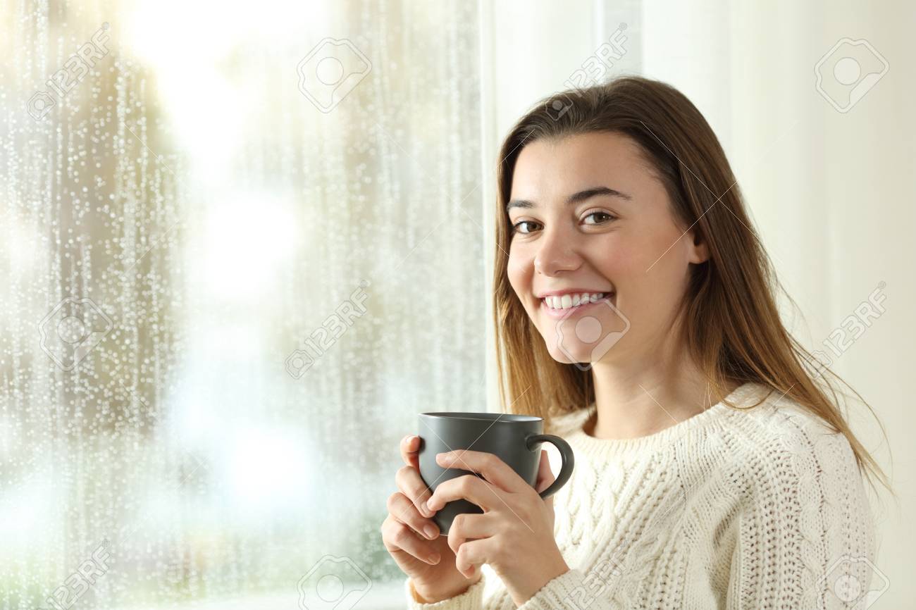 十代の持ち株コーヒー マグカップ ポーズを見て家で雨の日の幸せ の写真素材 画像素材 Image