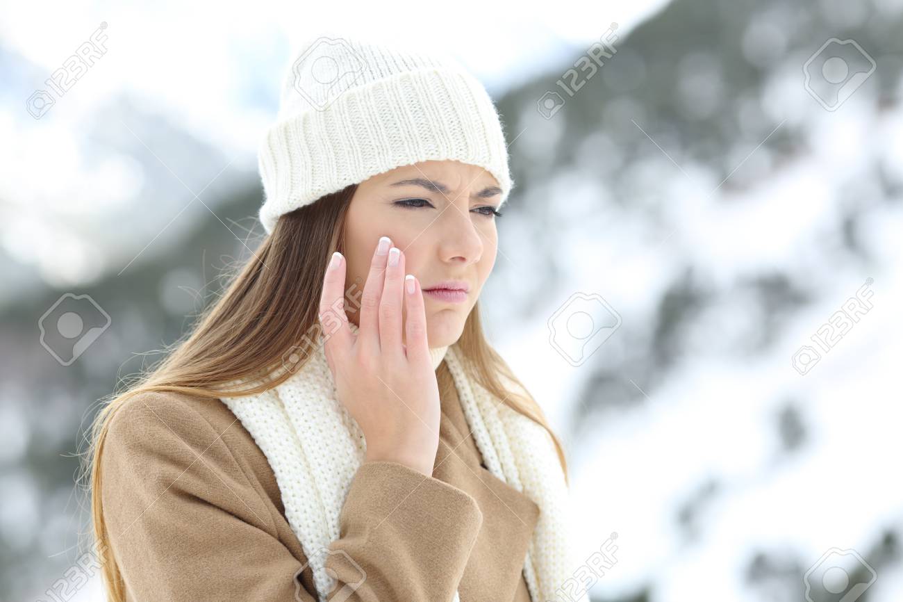 Angry woman using a sking protection moisturizer cream in winter in a snowy mountain - 93114283 Angry woman using a sking protection moisturizer cream in winter in a snowy mountain - 93114283