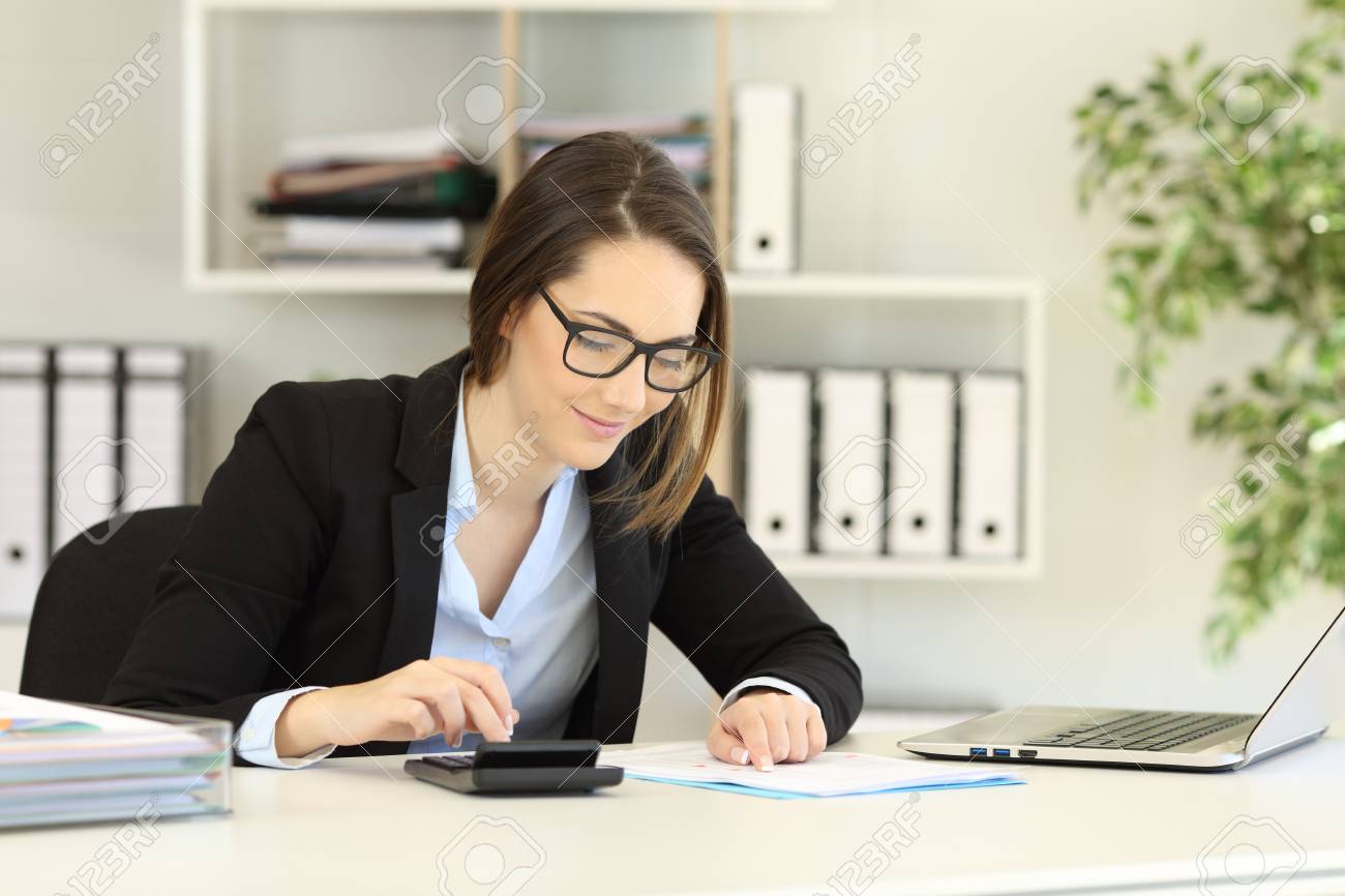 Office worker wearing eyeglasses doing accounting on a desk - 112439764 Office worker wearing eyeglasses doing accounting on a desk - 112439764