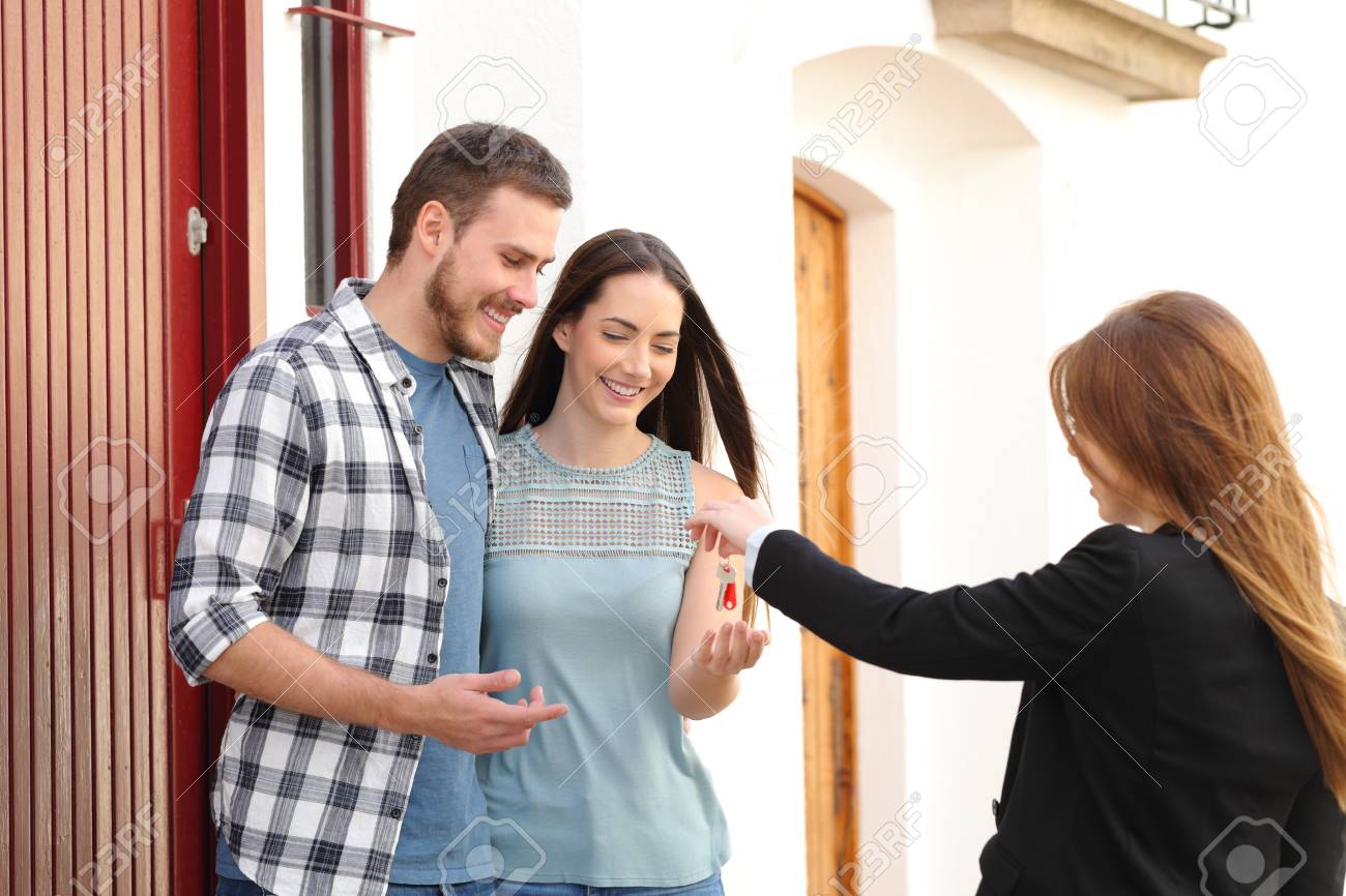 Happy couple of renters receiving house keys from real estate agent - 115370557 Happy couple of renters receiving house keys from real estate agent - 115370557