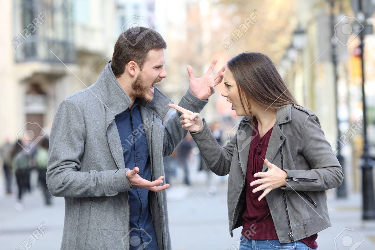 Angry couple arguing in the middle of a city street - 115370895 Angry couple arguing in the middle of a city street - 115370895