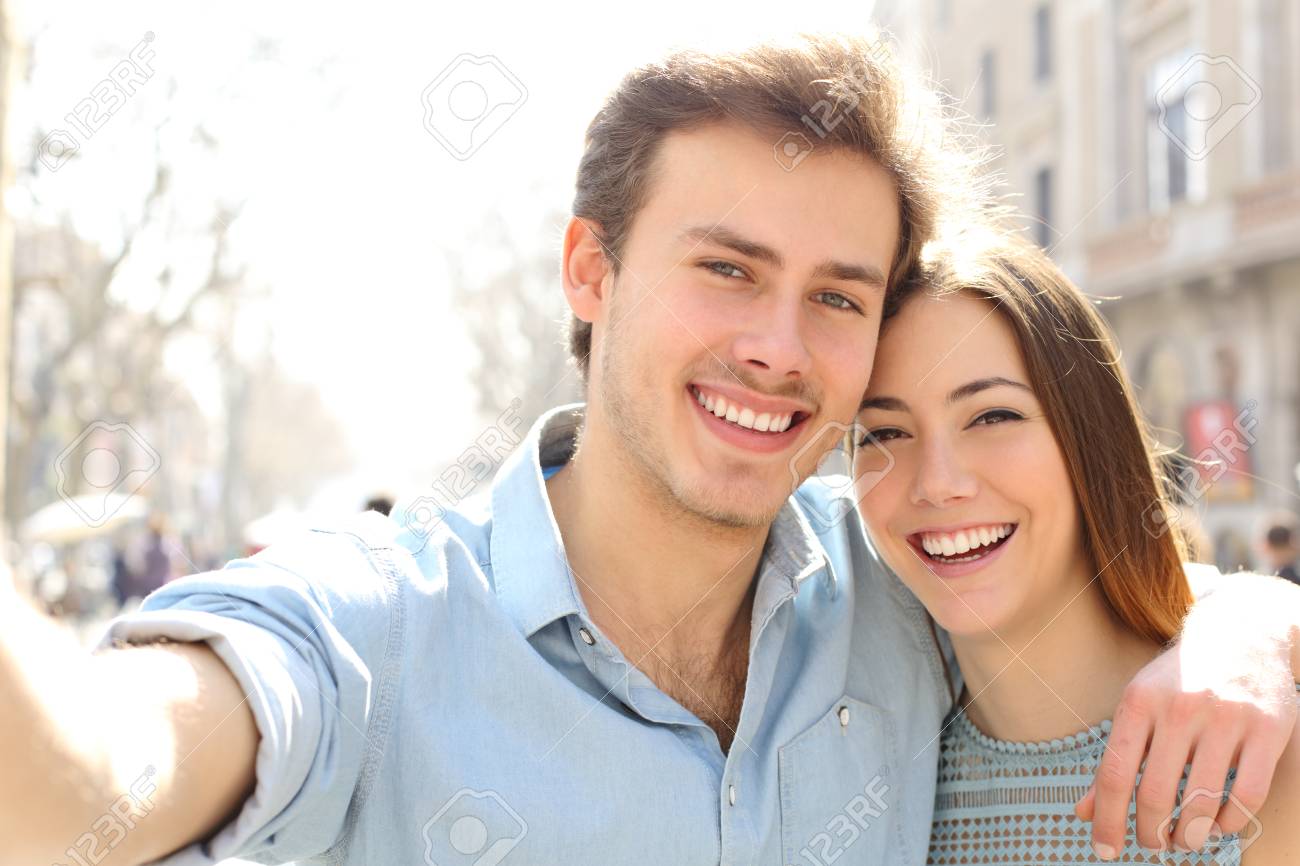 Happy couple are taking selfies in the street on summer holiday in a big city - 123603096 Happy couple are taking selfies in the street on summer holiday in a big city - 123603096