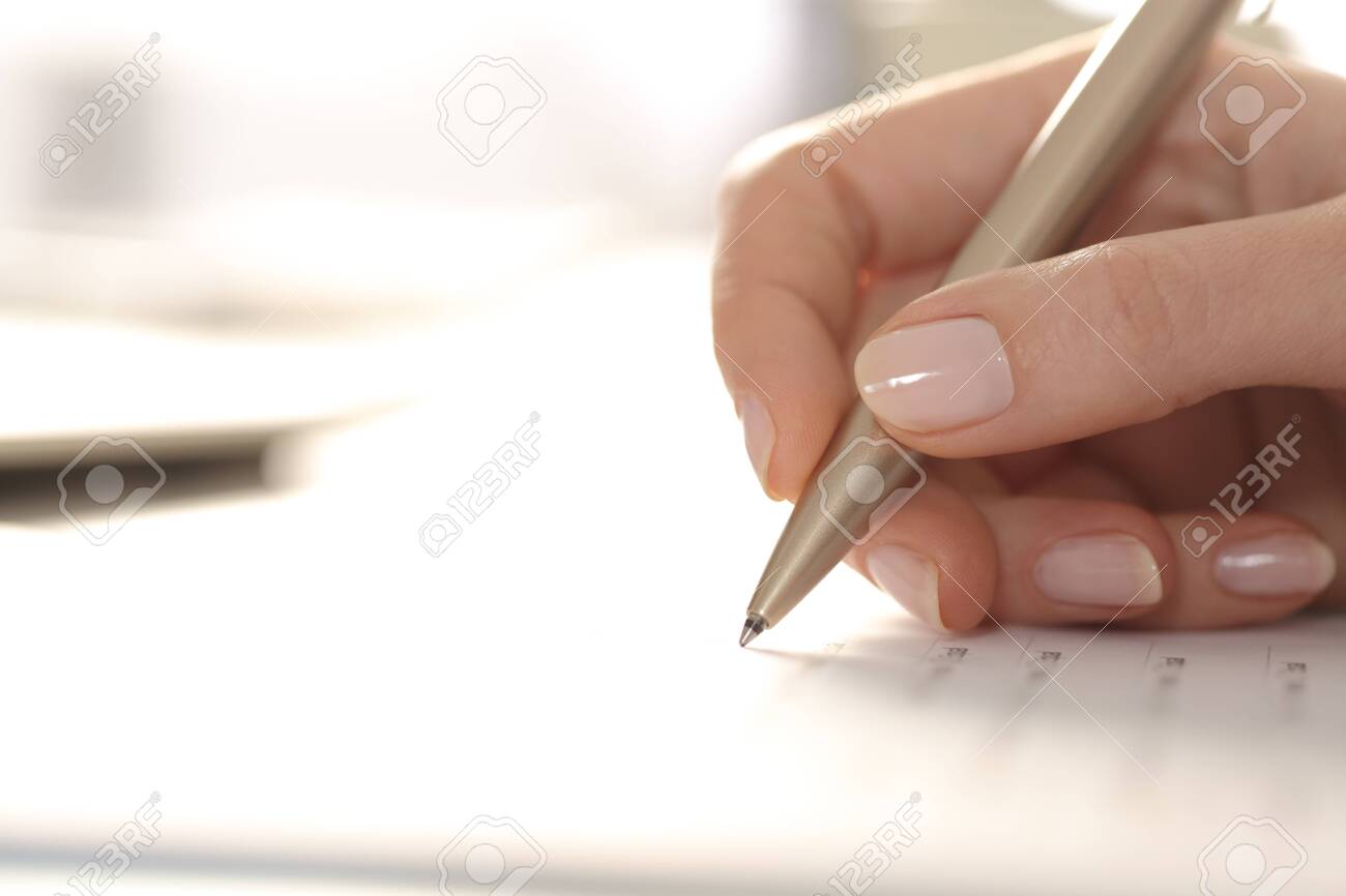 Close up of woman hand filling out form with pen on a desk - 144517200 Close up of woman hand filling out form with pen on a desk - 144517200