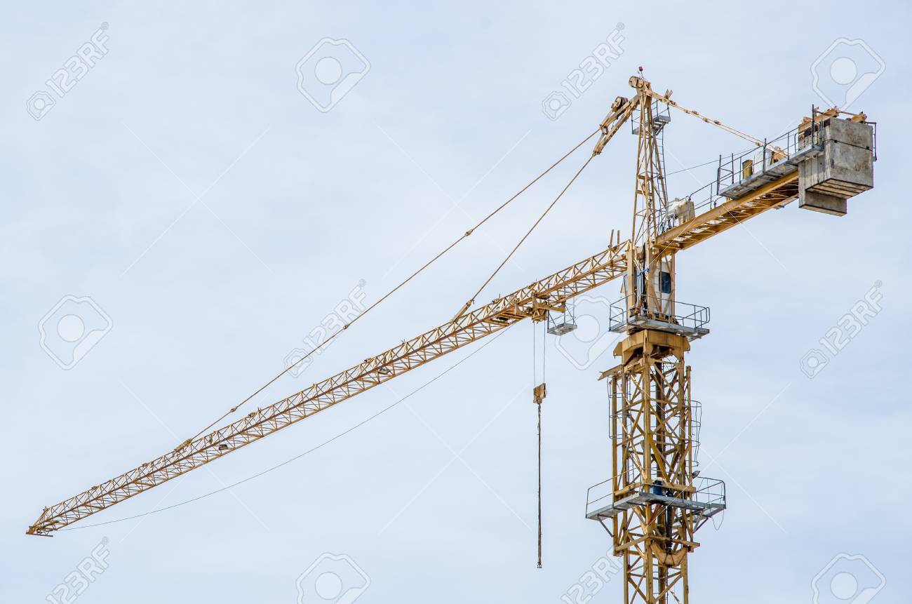 白い雲の背景を持つ黄色のタワー クレーンの写真素材・画像素材