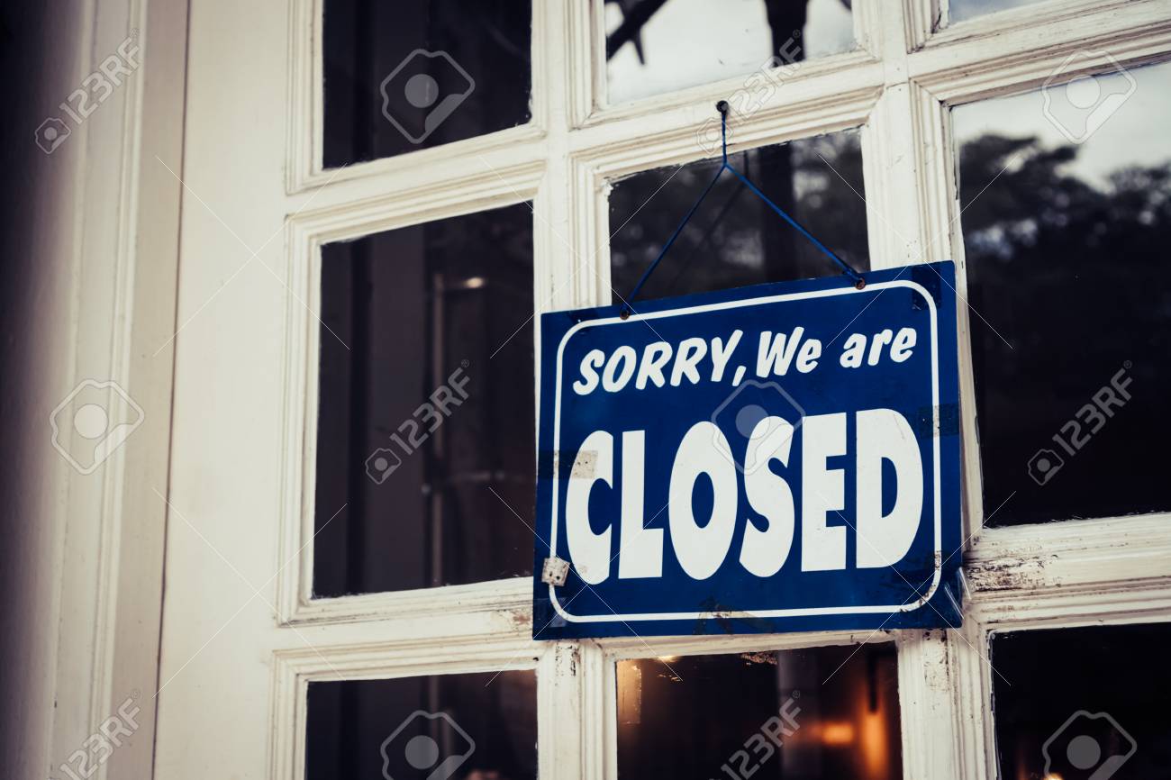 A Sign board of sorry we are closed hang on door of business shop with nature green background - 113372638 A Sign board of sorry we are closed hang on door of business shop with nature green background - 113372638