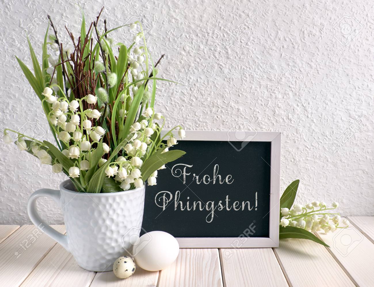 陶器の鶏 卵 谷の花のユリで飾られた黒板とイースター構成 キャプション フロヘ フィンステン は ドイツ語で ハッピーペンテコステ を意味します の写真素材 画像素材 Image