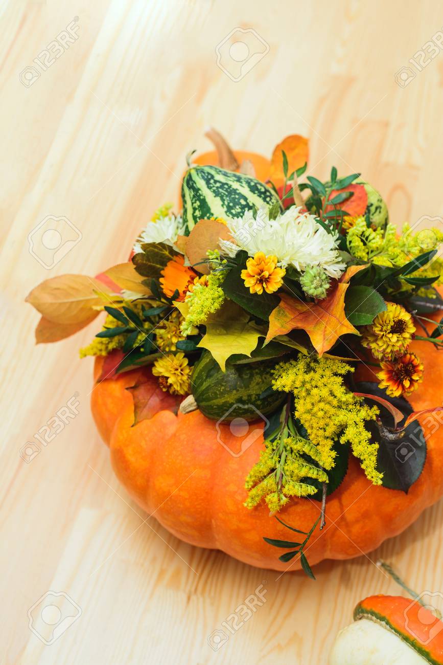 Un Bouquet Dautomne De Citrouilles Décoratives De Fleurs Et De Feuilles Dans Un Vase De Citrouille Orange Sur Une Table En Bois