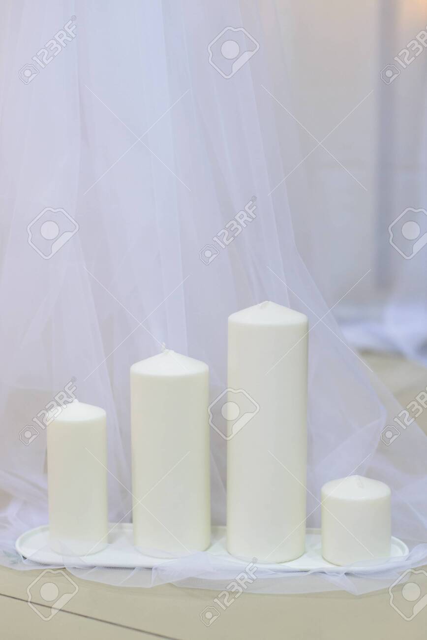 White Thick Wax Candles Group In Row Standing On Floor With Tulle