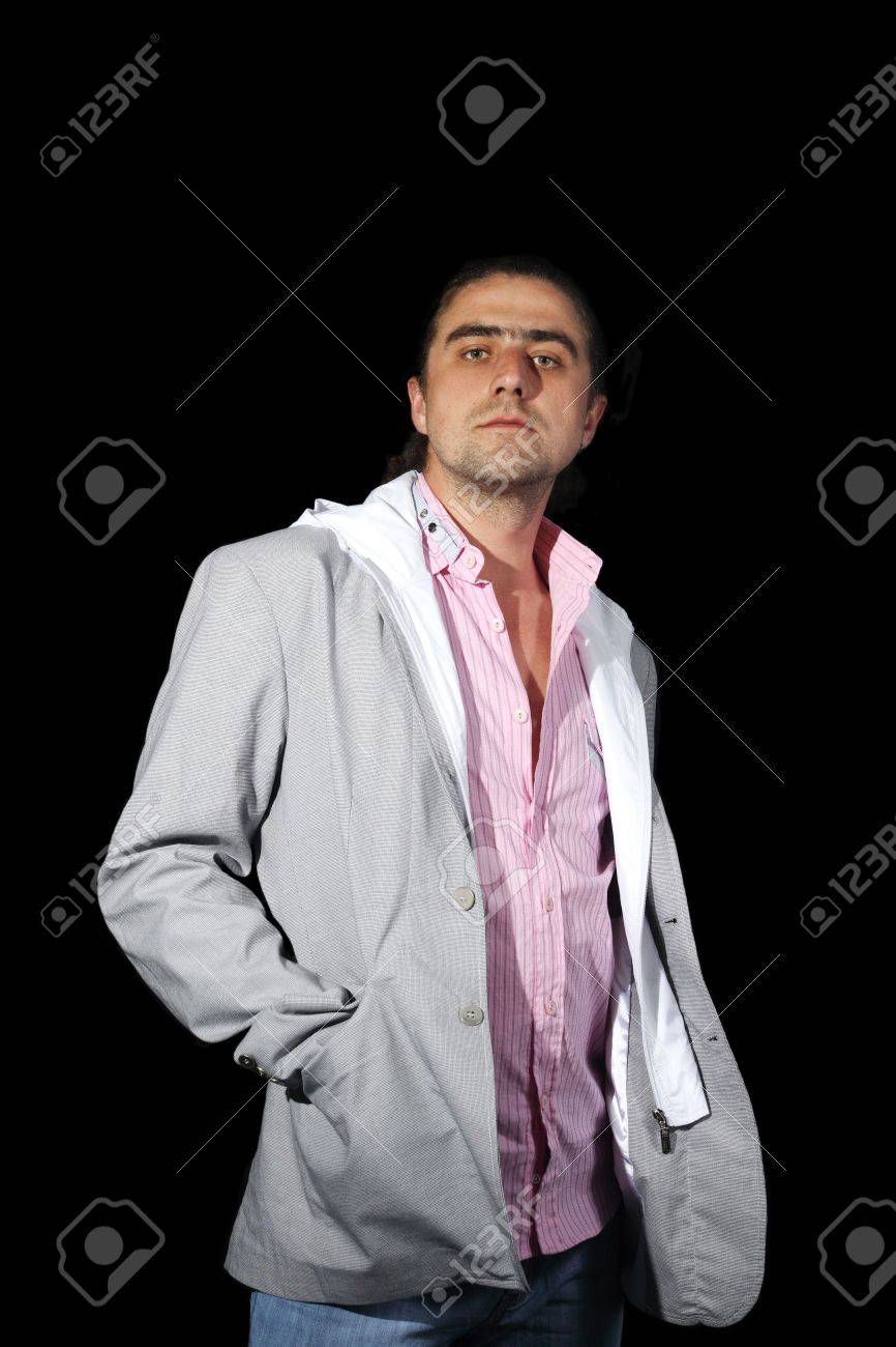 Jeune Homme Dans Un Costume Gris Et La Chemise Rose Sur Fond Noir