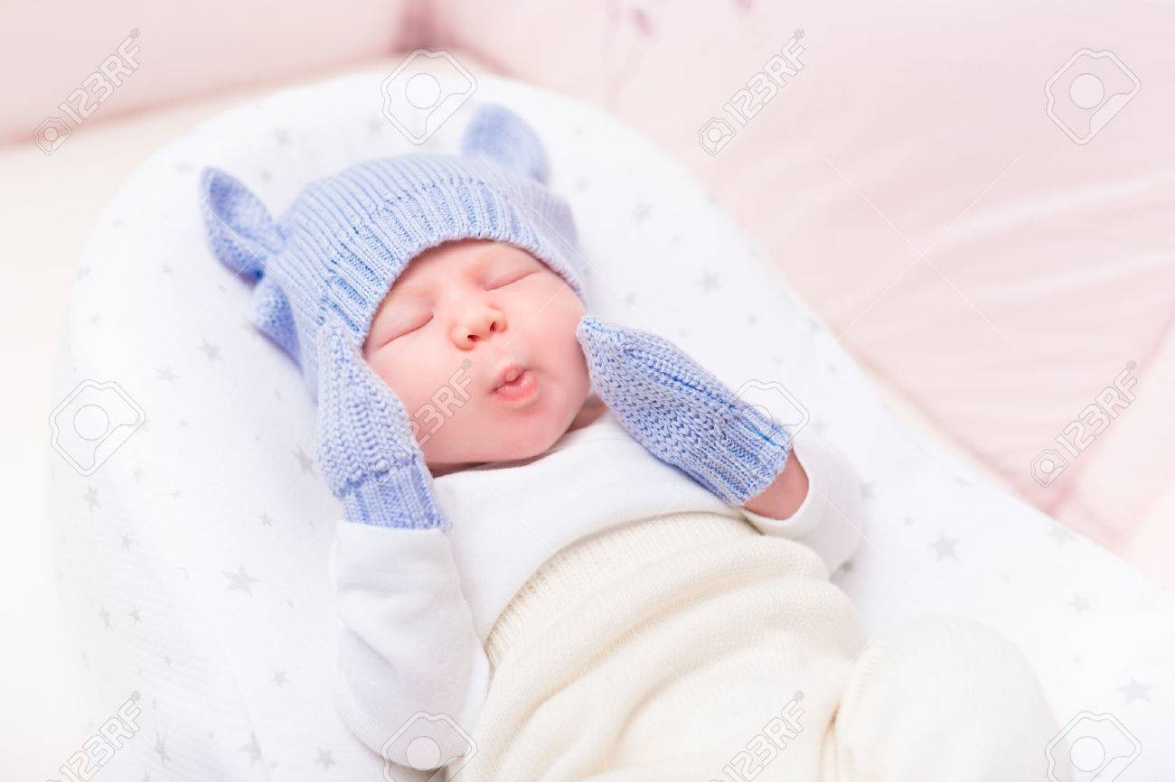 Mignon Petit Bebe Portant Tricote Chapeau Bleu Avec Des Oreilles Et Des Mitaines Couche Dans Le Berceau Belle Les Yeux Fermes Et Faire Drole De Tete La Securite Et La Garde D Enfants Mignon Petit Bebe Portant Tricote Chapeau Bleu Avec Des Oreilles Et Des Mitaines Couche Dans Le Berceau Belle Les Yeux Fermes Et Faire Drole De Tete La Securite Et La Garde D Enfants