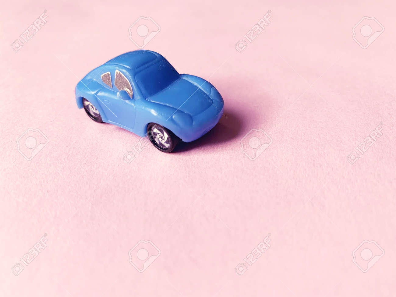 blue toy car on pink paper background - 169603107 blue toy car on pink paper background - 169603107