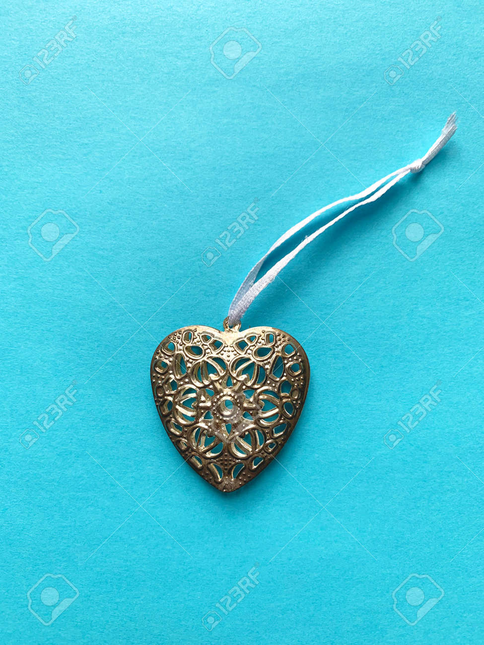 Metal heart pendant on a blue background - 169603111 Metal heart pendant on a blue background - 169603111