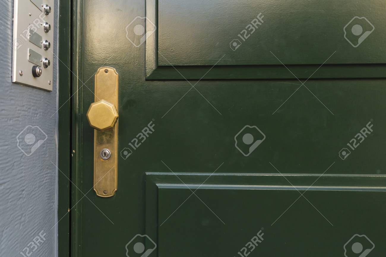 A Dark Green Painted Wooden Door With Golden Octagonal Knob And