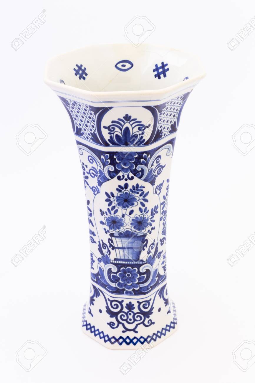 A tall ancient white ceramic flower vase painted with dark blue photo a tall ancient white ceramic flower vase painted with dark blue ornaments isolated on white backgrou