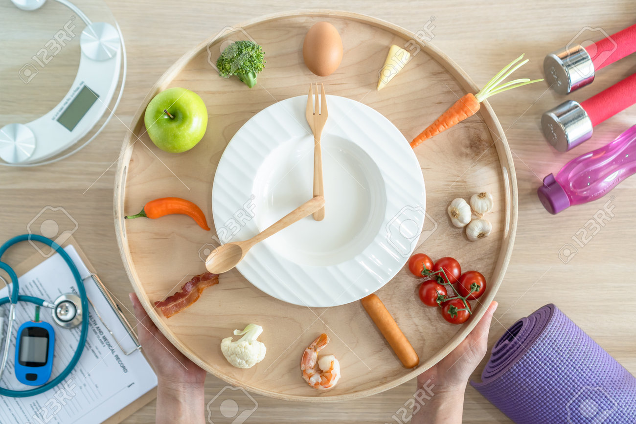 Intermittent fasting IF diet concept with 16:8 hour clock timer for skipping meal and eating keto low carb, high fat food meal healthy nutritional dish with gym exercise for body weight loss - 167146794 Intermittent fasting IF diet concept with 16:8 hour clock timer for skipping meal and eating keto low carb, high fat food meal healthy nutritional dish with gym exercise for body weight loss - 167146794
