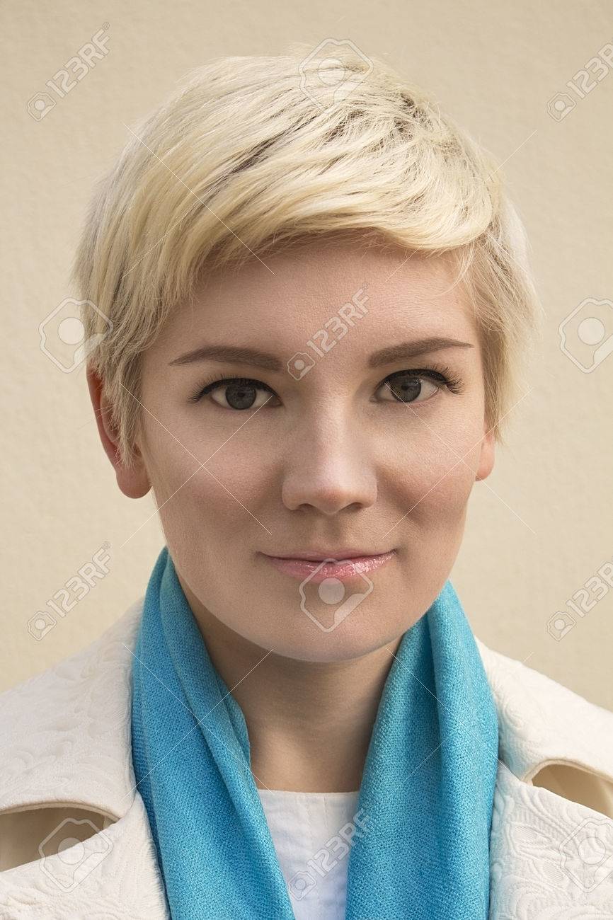 Close Up Portrait élégant De La Belle Jeune Femme Blonde Portant Un Foulard Bleu Et Blanc Manteau Isolé Sur Fond Beige Fille Avec Les Cheveux Courts