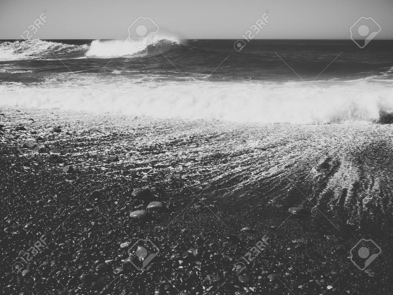 Seascape photo of a beach with dramatic waves black and white