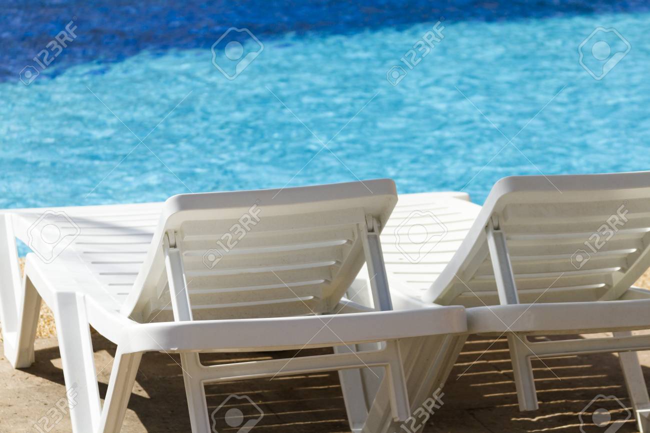 White Plastic Pool Chairs At The Swimming Pool Stock Photo