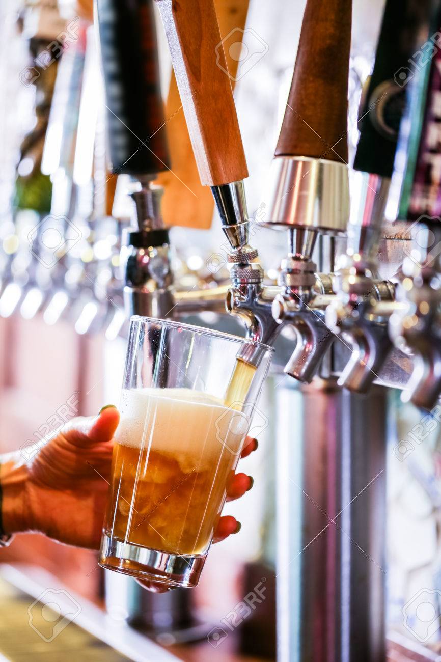 Bartender pouring draft beer in the bar. - 40793214 Bartender pouring draft beer in the bar. - 40793214
