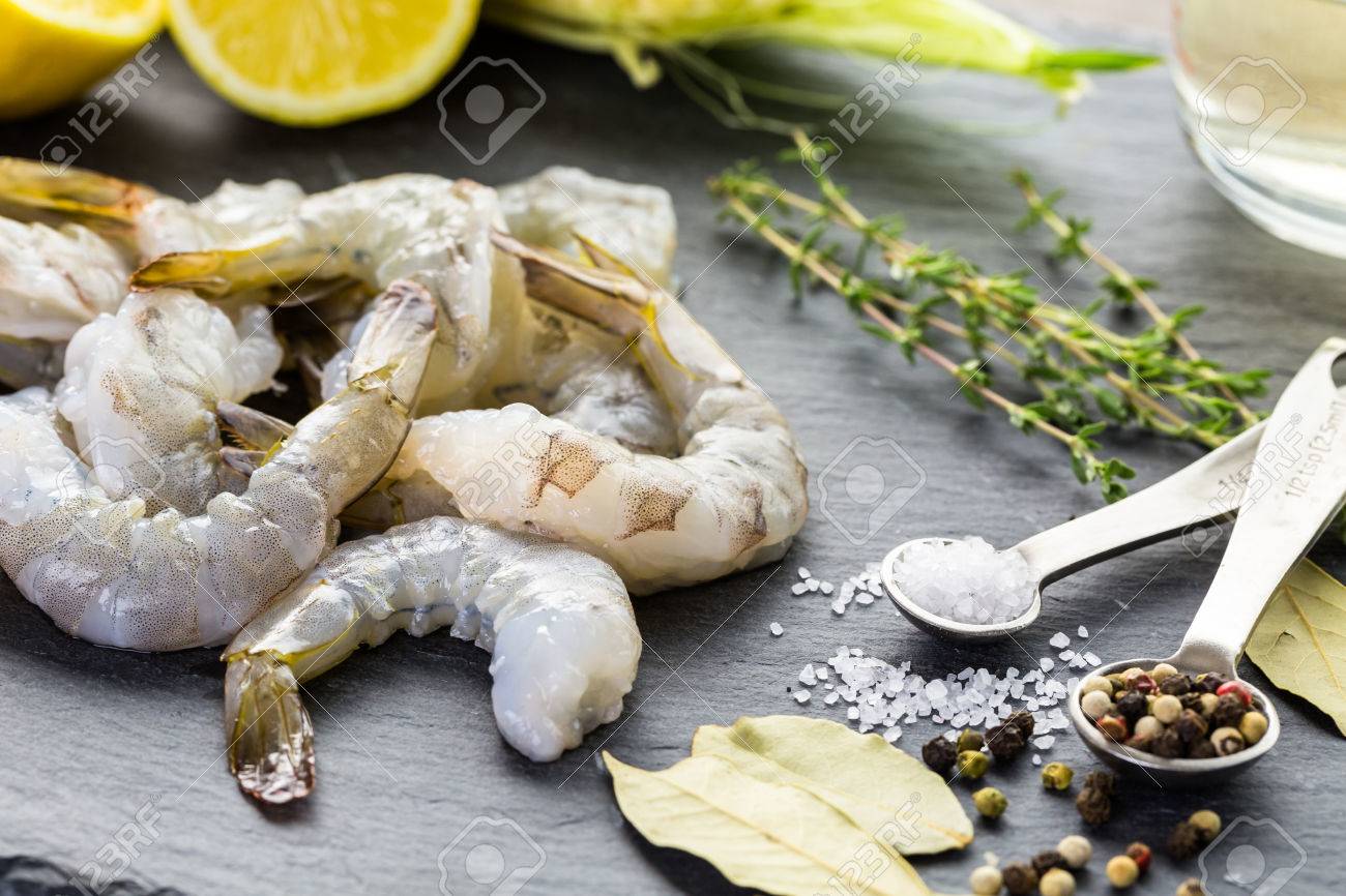 Raw peeled shrimp with tails with lemon on sutting board. - 44670528 Raw peeled shrimp with tails with lemon on sutting board. - 44670528