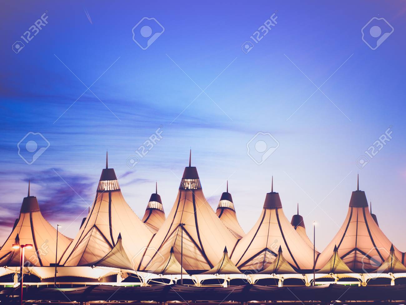 Glowing tents of DIA at sunrise. Denver International Airport well known for peaked roof. Design of roof is reflecting snow-capped mountains. - 47941995 Glowing tents of DIA at sunrise. Denver International Airport well known for peaked roof. Design of roof is reflecting snow-capped mountains. - 47941995