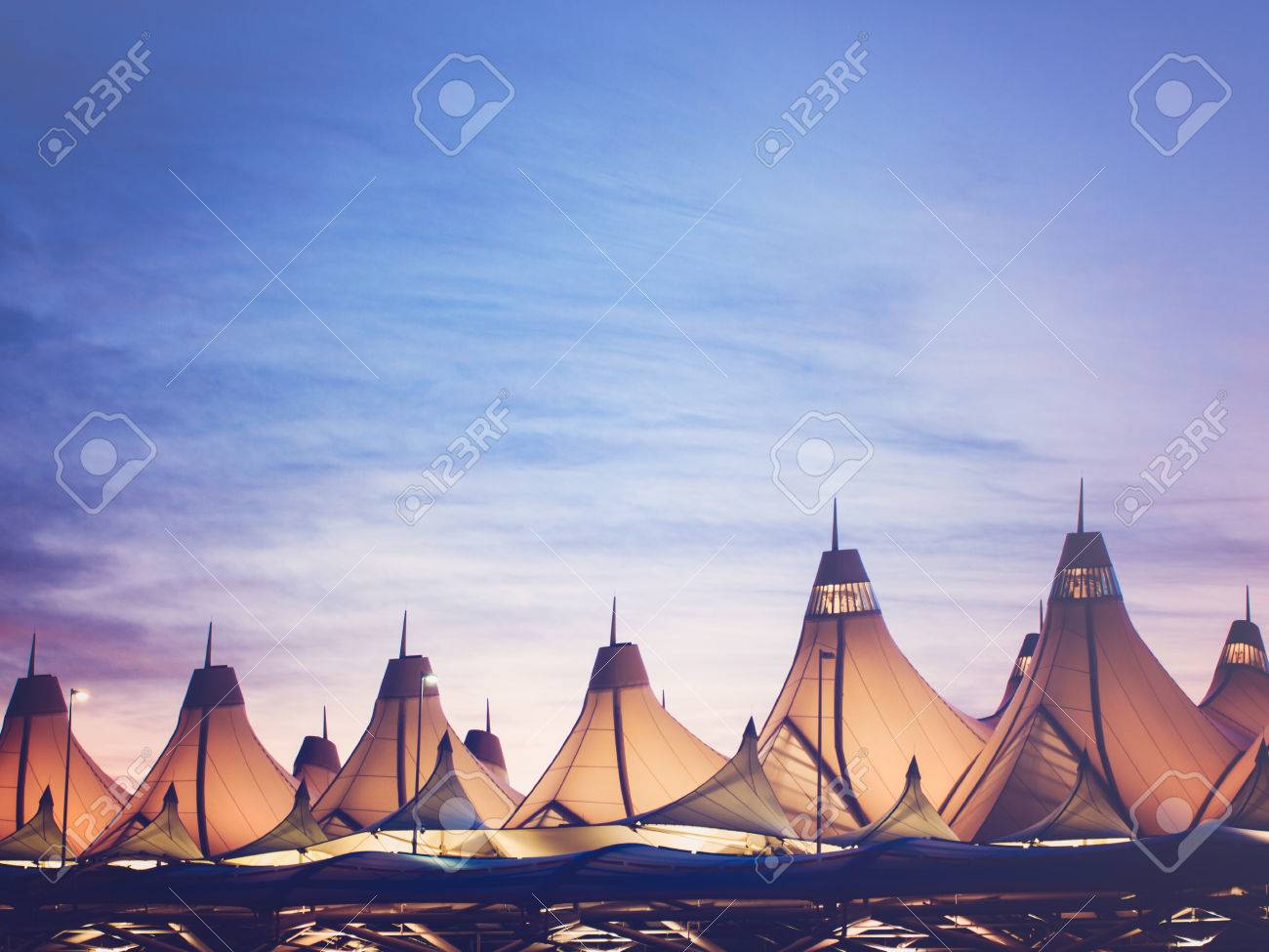 Glowing tents of DIA at sunrise. Denver International Airport well known for peaked roof. Design of roof is reflecting snow-capped mountains. - 47942071 Glowing tents of DIA at sunrise. Denver International Airport well known for peaked roof. Design of roof is reflecting snow-capped mountains. - 47942071