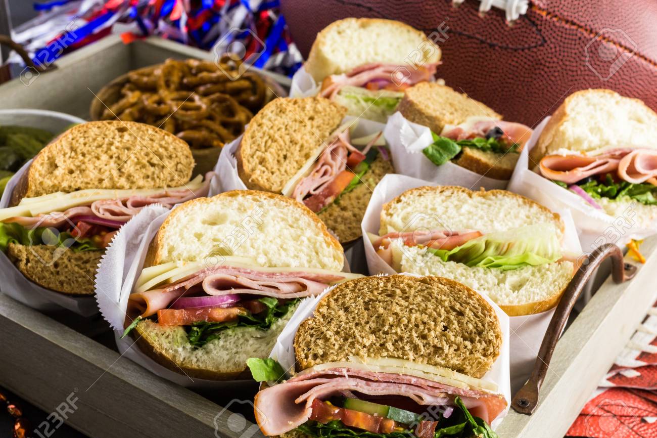 game day football party table with sub sandwich and snacks stock