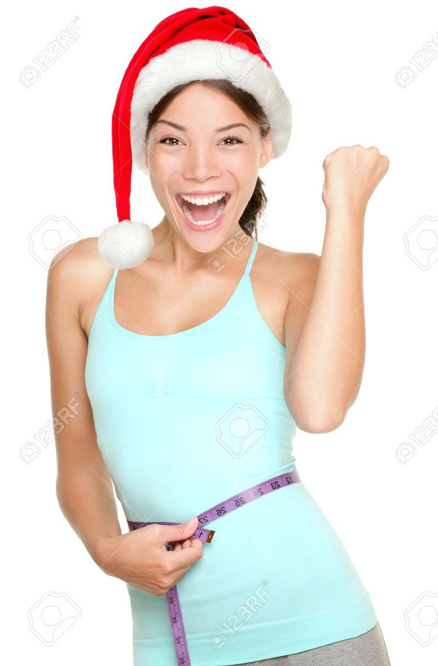 Christmas fitness woman excited about weight loss measuring waist with measuring tape wearing santa hat screaming excited Mixed race fitness model isolated on white - 15717299 Christmas fitness woman excited about weight loss measuring waist with measuring tape wearing santa hat screaming excited Mixed race fitness model isolated on white - 15717299