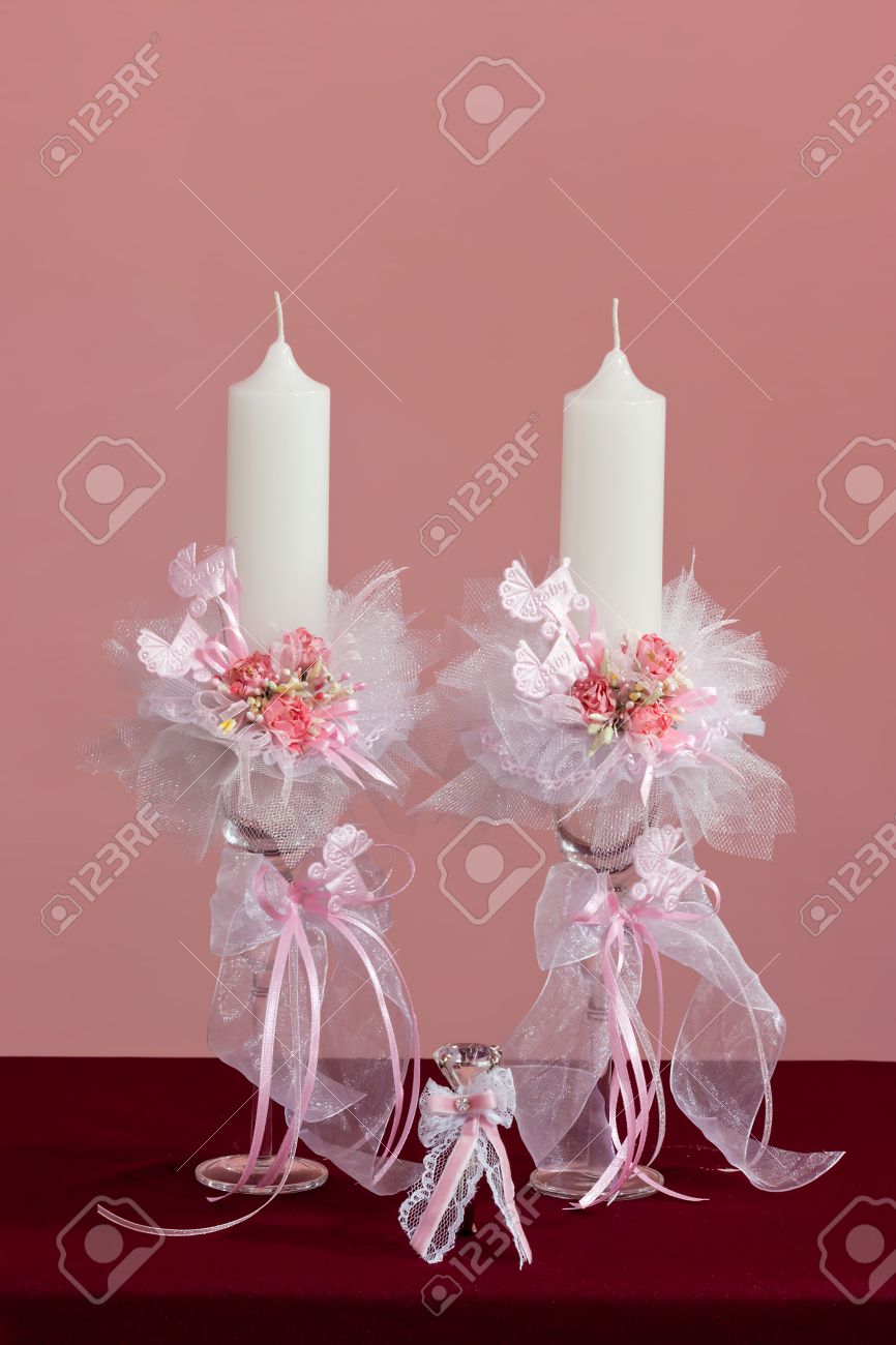 baby girl christening candles with artificial pink flowers and