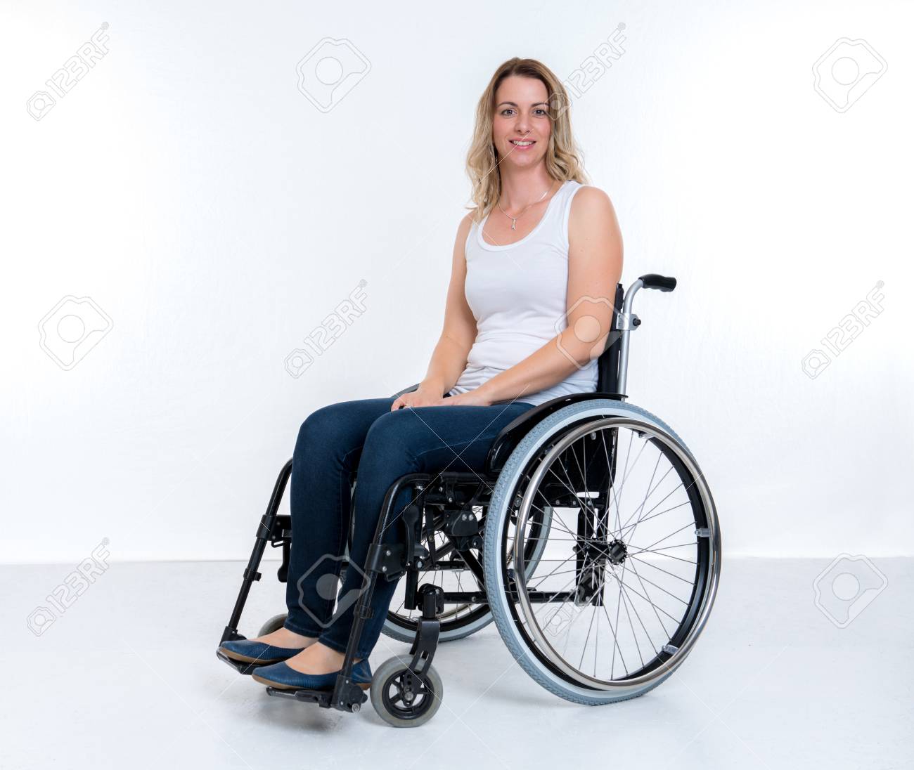 young disabled woman in wheelchair infront of white background stock