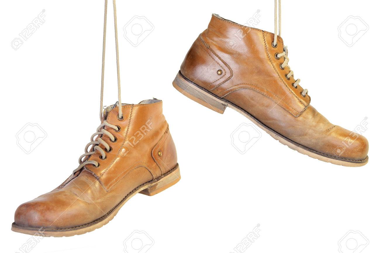 A pair of old leather boots with laces hanging