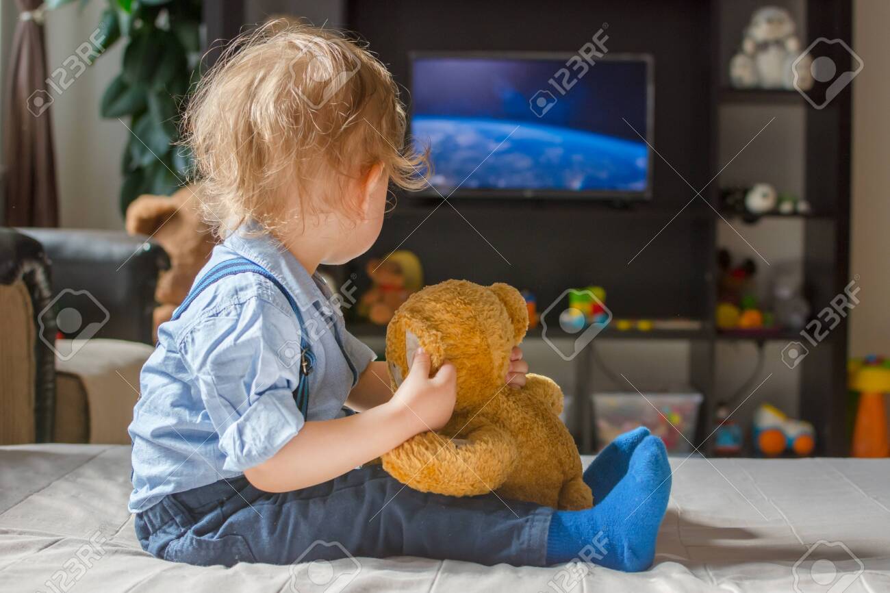 Cute Baby Boy And His Teddy Bear Watching Tv Sitting On A Couch Stock Photo Picture And Royalty Free Image Image 150361296