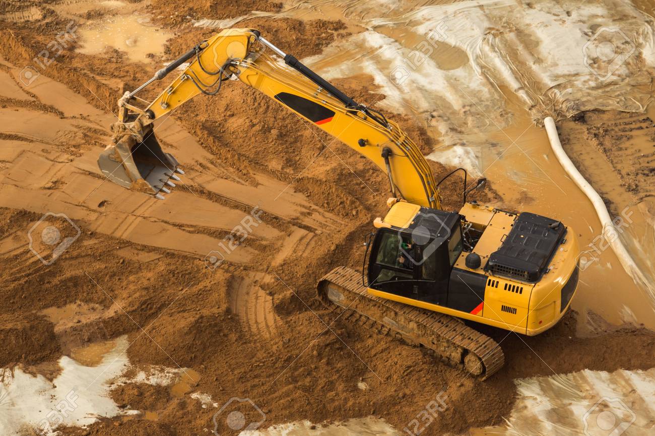 view from above at working excavator tractor digging a trench stock