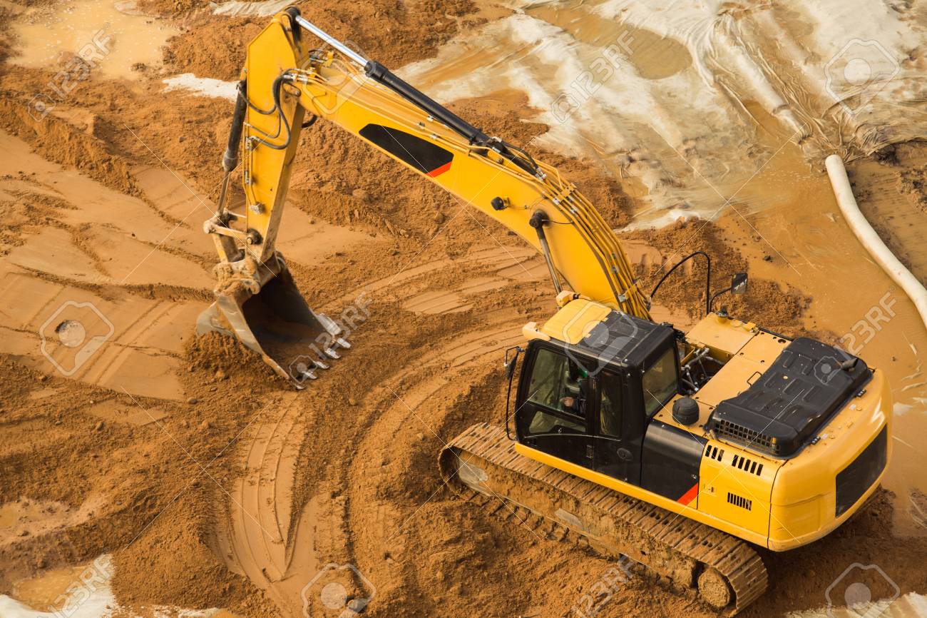view from above at working excavator tractor digging a trench stock