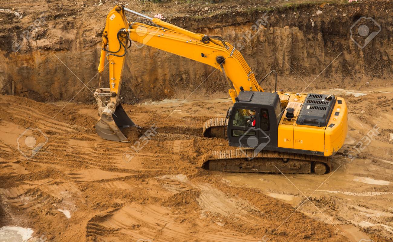 view from above at working excavator tractor digging a trench stock