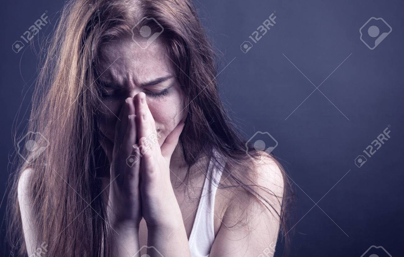 Young Woman Crying Face In Her Hands On A Dark Background Stock Photo,  Picture and Royalty Free Image. Image 35228576.
