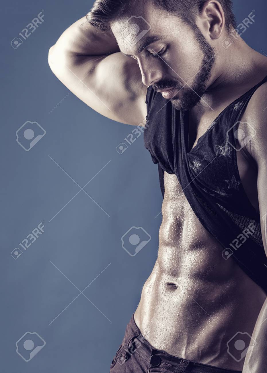 彼の T シャツを持ってセクシーな男は 明らかに彼の理想的な腹部の筋肉 の写真素材 画像素材 Image